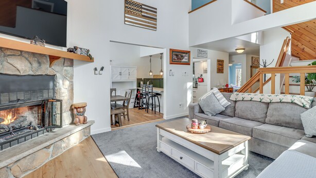 A spacious living room with a stone fireplace, a flat-screen TV, and a comfortable seating area. - 1 Mi to Big Boulder Mountain: Townhome W/gas Grill (Lake Harmony)