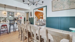 A modern kitchen with a wooden dining table, bar stools, and pendant lighting. - 1 Mi to Big Boulder Mountain: Townhome W/gas Grill (Lake Harmony)