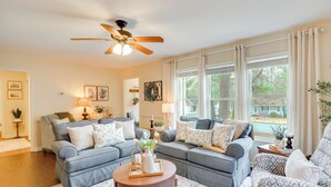 A living room with two grey sofas, a round coffee table, and a ceiling fan. - 'petals & Pillows Getaway' 1 Mi to Dtwn Wendell! (Wendell)