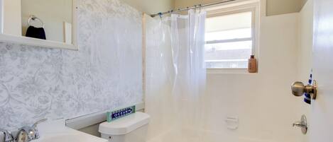 A bathroom with a toilet, sink, and bathtub.