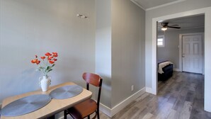 A dining area with a table, chairs, a vase with flowers, and a ceiling fan in the background. - Huntsville Studio w/ Workspace Near Downtown (Huntsville)