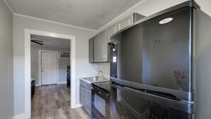 A modern kitchen with a stainless steel refrigerator, a dishwasher, and a sink. - Huntsville Studio w/ Workspace Near Downtown (Huntsville)