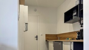 A compact kitchen with a white door, a built-in dishwasher, and a wooden countertop. - #IH - Le Victoria 4 💟 (Grenoble)