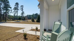 A porch with a white exterior, a clear sky, and a grassy area with trees in the background. - 4 Mi to Surf City Beaches! Family Coastal Retreat (Hampstead)