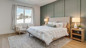 A bedroom with a bed, two bedside tables with lamps, a chair, a window with curtains, and a ceiling fan. - 4 Mi to Surf City Beaches! Family Coastal Retreat (Hampstead)
