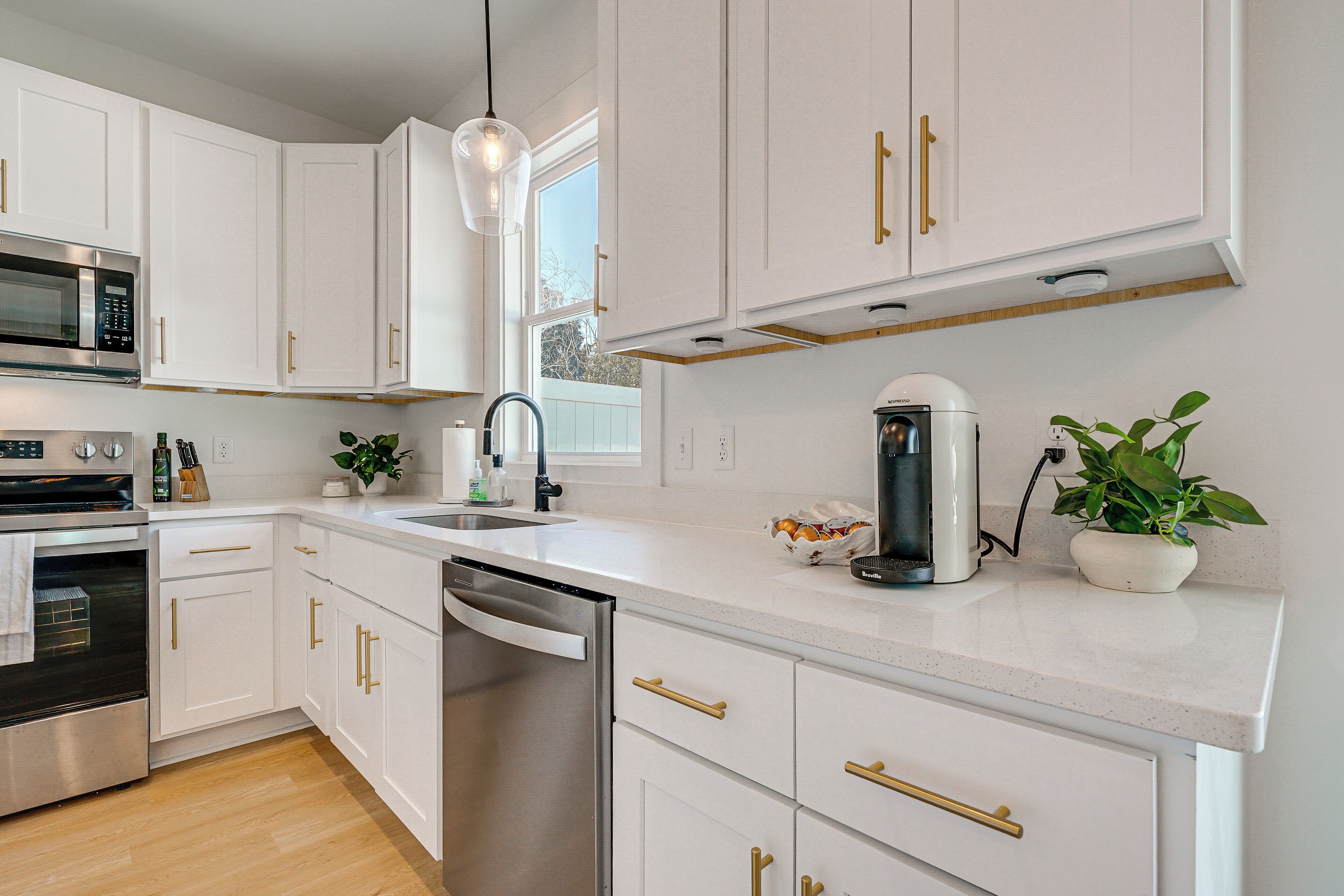 A modern kitchen with white cabinets, stainless steel appliances, and a dishwasher.