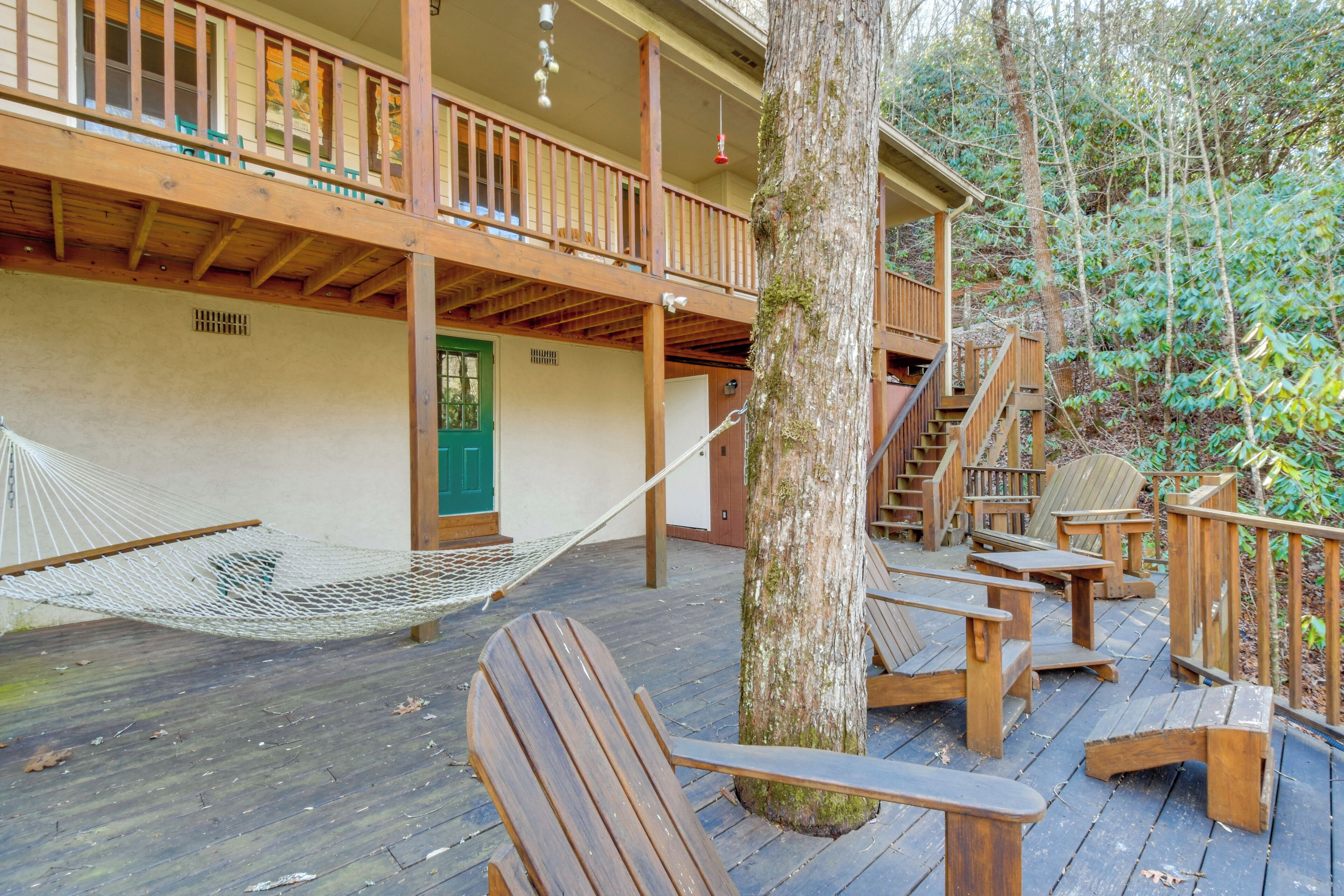 Eine Holzterrasse mit Sitzgelegenheiten und einer Hängematte.