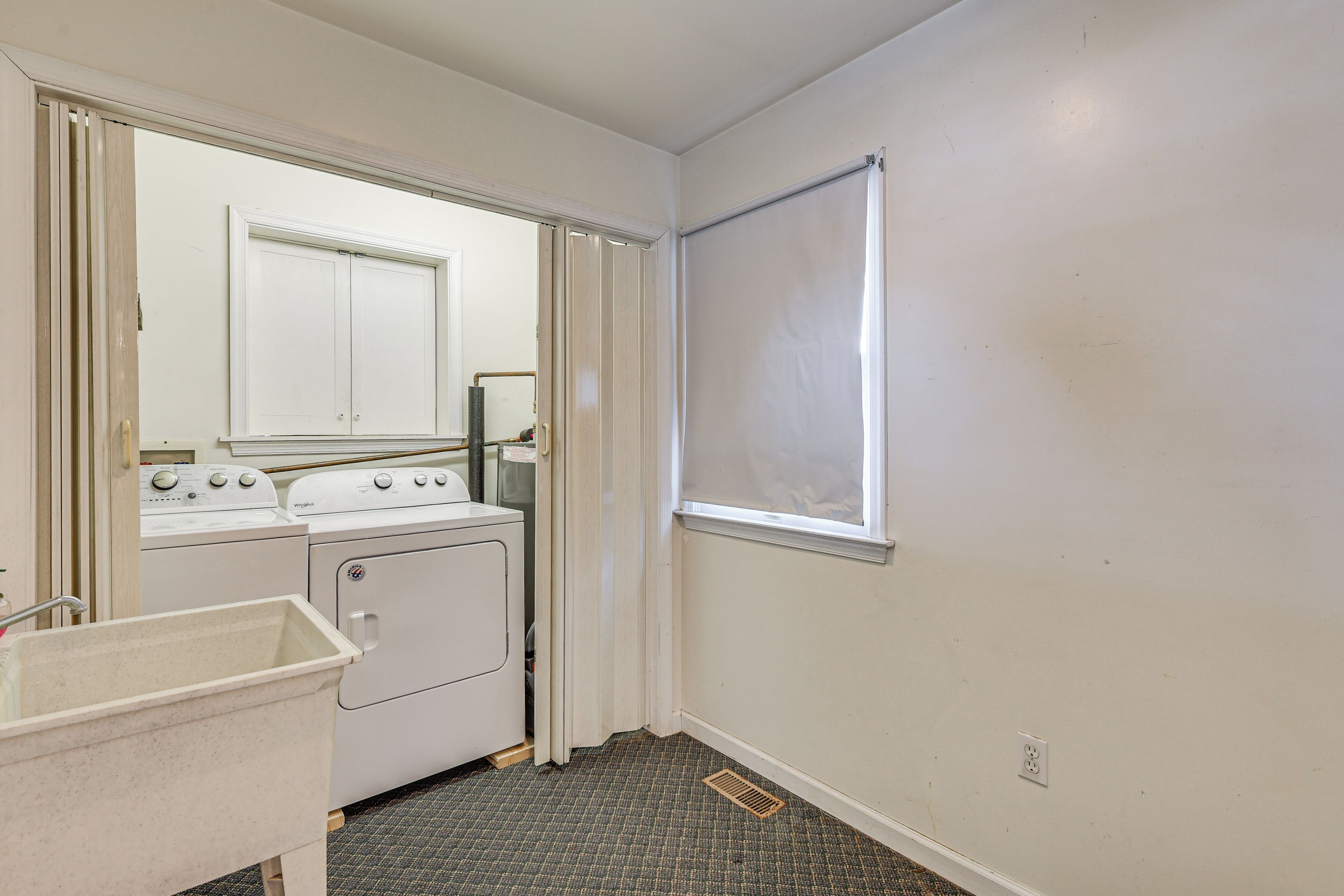 A laundry area with a washing machine, dryer, and a utility sink.