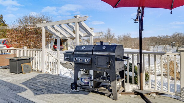 A barbecue grill on a wooden deck with a red umbrella overhead. - Peaceful Getaway w/ Countryside Views in Upperco (Upperco)