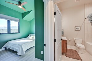Une chambre à coucher avec un lit, un ventilateur de plafond et une fenêtre donnant sur un beau paysage.