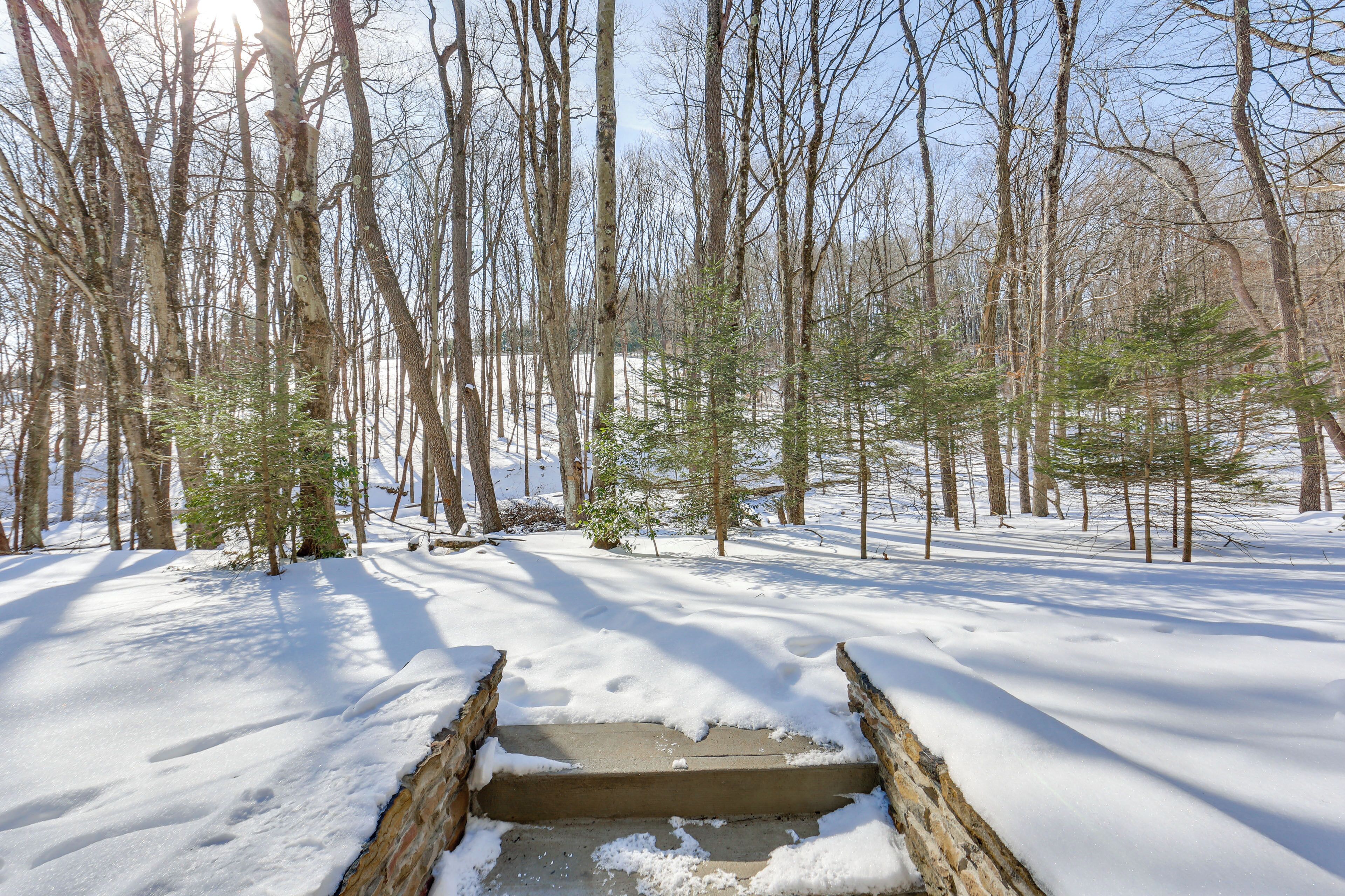 A snow-covered wooden bridge in a forest.