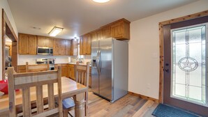 Eine Küche mit Holzausstattung, Edelstahlgeräten und einem großen Kühlschrank.