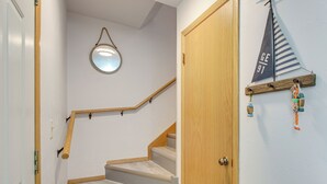Una escalera con barandillas de madera y un espejo redondo en la pared.