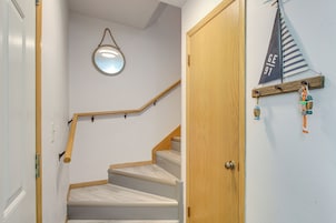 A staircase with wooden handrails and a round mirror on the wall.