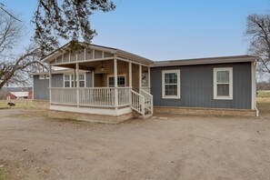 A single-story house with a covered porch and a small front yard. - Steps to WES Arena: Pet-friendly Cabin w/ Deck! (Blue Ridge)