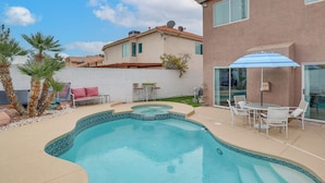 A swimming pool with a tiled edge, surrounded by a patio area with chairs and a table. - Private Pool, Fire Pit & Grills: Las Vegas Getaway (Las Vegas)
