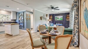 A modern kitchen with a dining area, wooden flooring, and a ceiling fan. - Riverfront Oasis: Fish, Grill & Chill in Stuart! (Stuart)