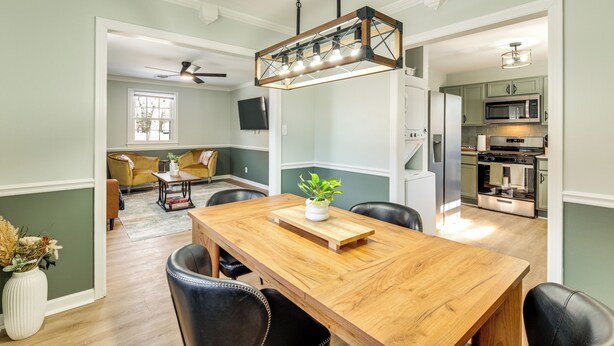 A dining area with a wooden table, black leather chairs, and a hanging light fixture. - 5 Mi to Fort Gregg-adams: Spacious Family Home (Colonial Heights)