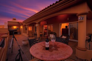 An outdoor patio area with a round table, chairs, and a telescope. - Steps to Sand: Ocean-view Cabo Home w/ Heated Pool (Cabo San Lucas)