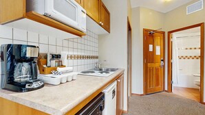 A compact kitchen with a coffee maker, microwave, and dishwasher. - Whistler - Cascade Lodge 114 (Whistler)
