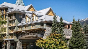 Ein mehrstöckiges Gebäude mit Steinaußenwand und Balkonen, beschriftet mit "Cascade Lodge".