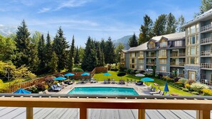 Un hotel con piscina, zona de estar al aire libre y vistas a las montañas.