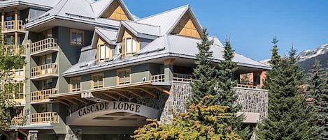 A multi-story building with a stone facade and balconies, labeled "Cascade Lodge."