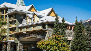 Un immeuble à plusieurs étages doté de balcons, d’une façade en pierre et d’une enseigne indiquant « Cascade Lodge ».