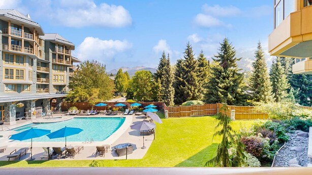 Un hôtel doté d’une piscine, d’un espace extérieur aménagé et offrant une vue sur les montagnes.
