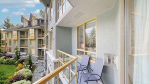 A multi-story residential building with balconies, a garden area with various plants, and a clear sky. - Whistler - Cascade Lodge 212 (Whistler)