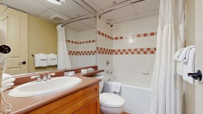 Een badkamer met een wastafel, spiegel, toilet en douche.