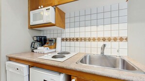 A compact kitchen with a microwave, coffee maker, and a sink. - Whistler - Cascade Lodge 230 (Whistler)