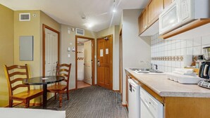 Cocina compacta con comedor, que incluye microondas, pileta y lavavajillas.