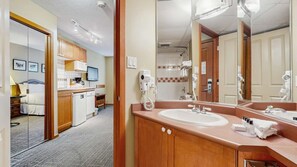 Ein Hotelzimmer mit Bad, Küchenzeile und einem Bett.