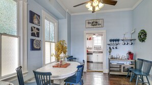 A dining area with a round table, blue chairs, and a ceiling fan. - Steps to Pleasure Pier: Family Escape w/ Pool! (Galveston)