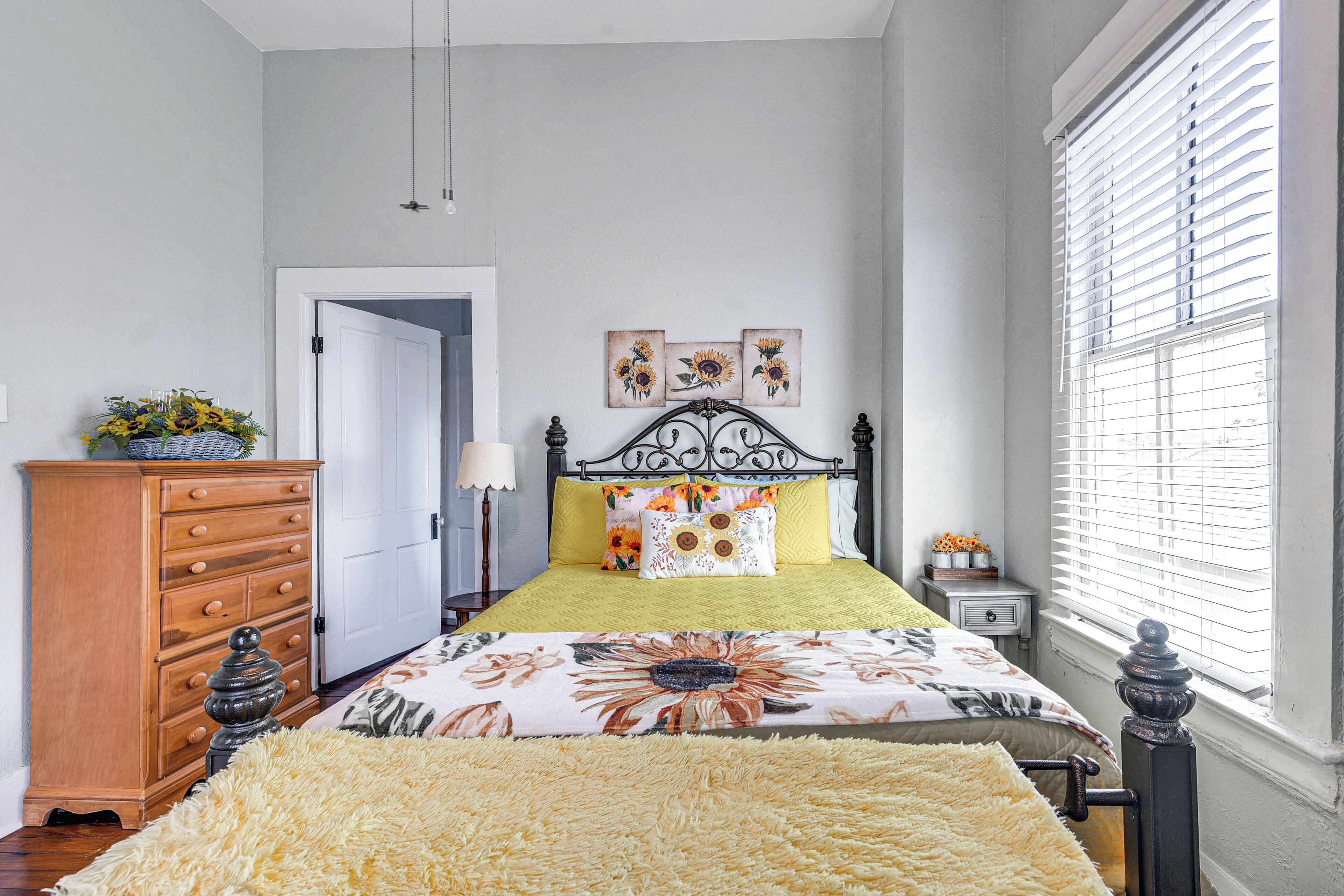 Un dormitorio con cama, cómoda y ventana con persianas.