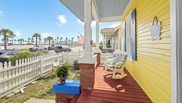 A yellow building with a porch, white picket fence, and a welcome sign. - Steps to Pleasure Pier: Family Escape w/ Pool! (Galveston)