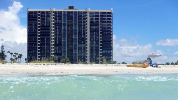 A high-rise hotel with a modern design, located near a beach with clear turquoise waters. - Walk to Sand Key! 11th-floor Clearwater Beach Gem (Clearwater Beach)