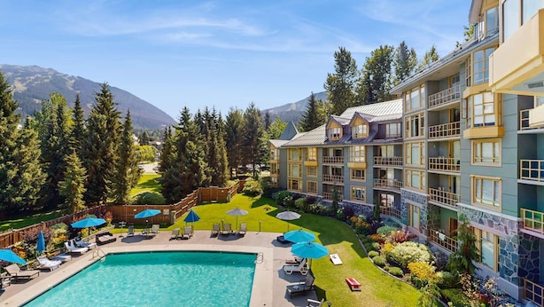 Ein Hotel mit Pool, Außenbereich und Bergblick.