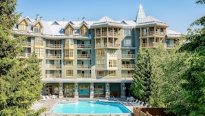 Ein mehrstöckiges Hotel mit Poolbereich, Balkone und einem markanten architektonischen Stil.