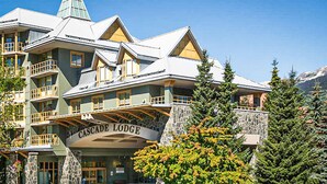 Un immeuble à plusieurs étages, doté de balcons et d’une enseigne indiquant « Cascade Lodge ».