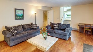 A living room with two grey sofas, a coffee table, and a painting on the wall. - Bring the Family! Suburban Home w/ Yard in Omaha (Omaha)