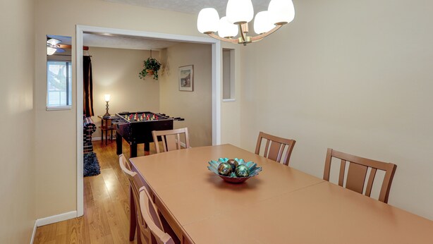 A dining room with a wooden table, chairs, and a chandelier. - Bring the Family! Suburban Home w/ Yard in Omaha (Omaha)