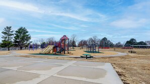 A playground with a slide, climbing structures, and picnic tables. - Bring the Family! Suburban Home w/ Yard in Omaha (Omaha)