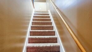 A carpeted staircase with a wooden handrail, leading to a landing. - Lake Murray Retreat Near USC & Columbia (Columbia)