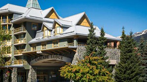 Un edificio de varios pisos con balcones y fachada de piedra, identificado como "Cascade Lodge".