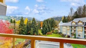 Un hôtel doté d’une piscine, offrant une vue sur les montagnes et entouré d’arbres aux couleurs automnales.