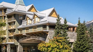Un immeuble à plusieurs étages, doté d’une façade en pierre et d’une enseigne indiquant « Cascade Lodge ».
