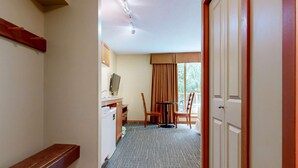 Une chambre d’hôtel équipée d’un bureau, d’une chaise et offrant une vue sur l’extérieur par une fenêtre.