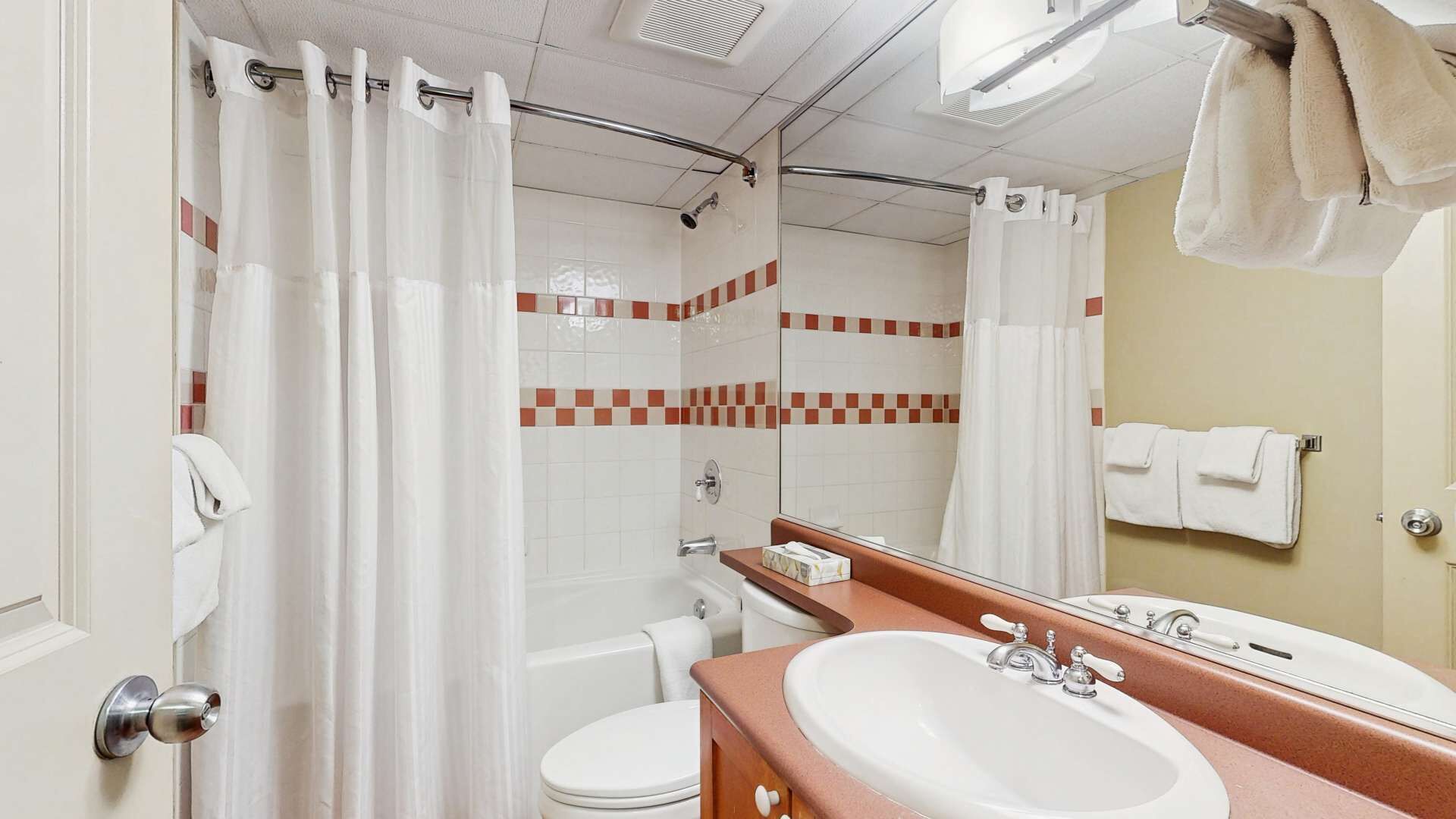 Ein Badezimmer mit Dusche, Toilette und Waschbecken.
